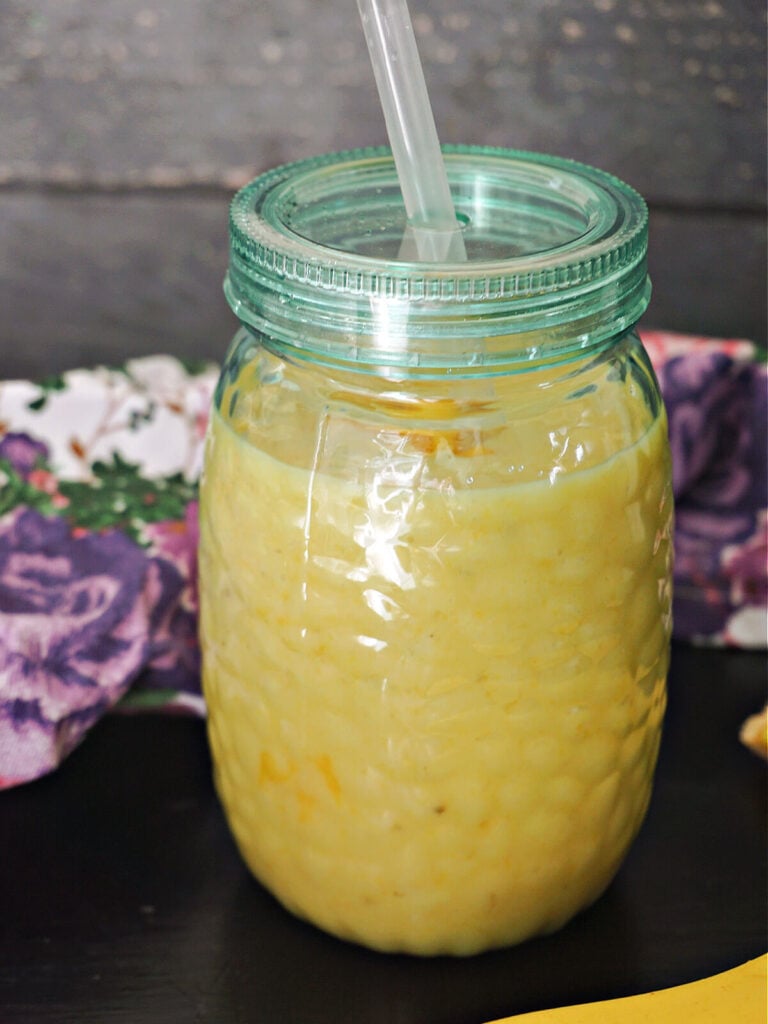 A glass with mango and banana smoothie
