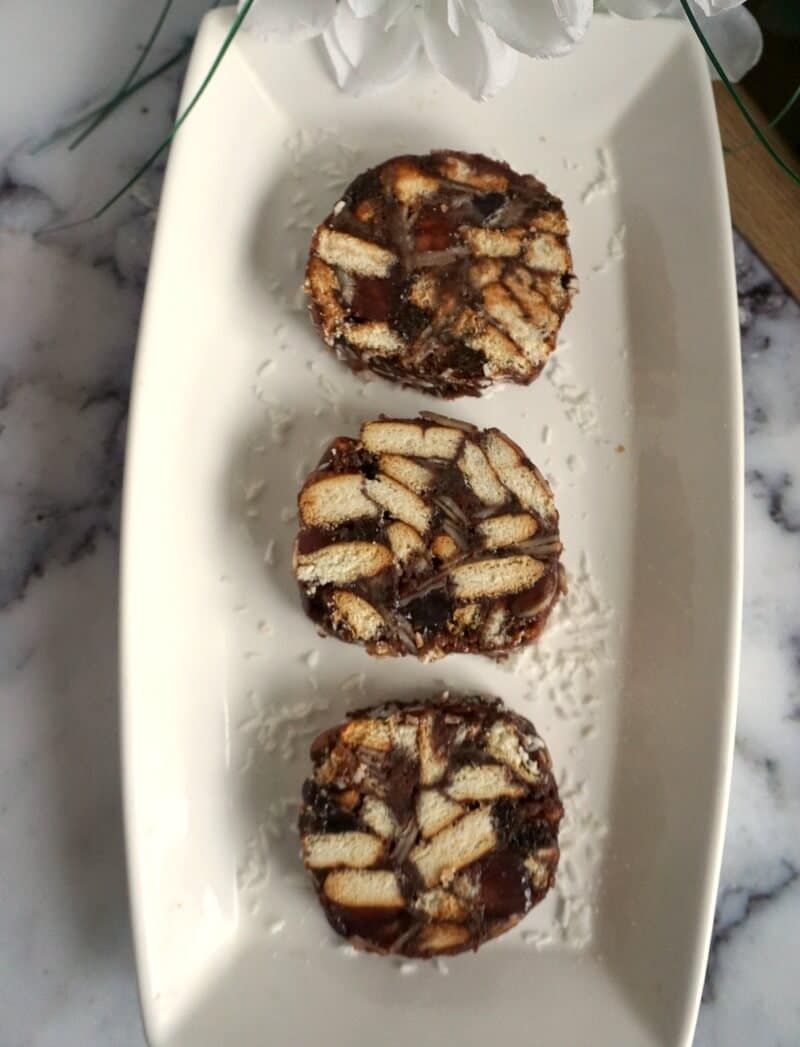 3 Chocolate Salami slices on a white rectangle plate.