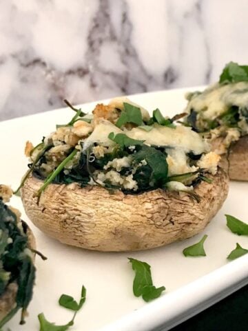 3 Spinach-Stuffed Mushrooms on a white serving plate