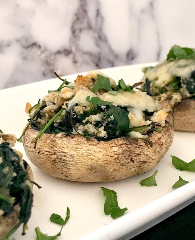 3 Spinach-Stuffed Mushrooms on a white serving plate