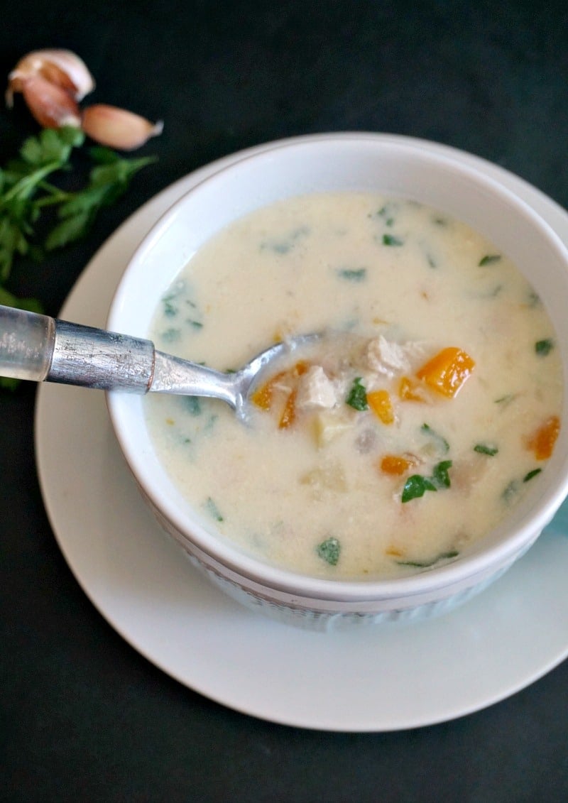 Overhead shot of a bowl of chicken soup with sour cream and garlic