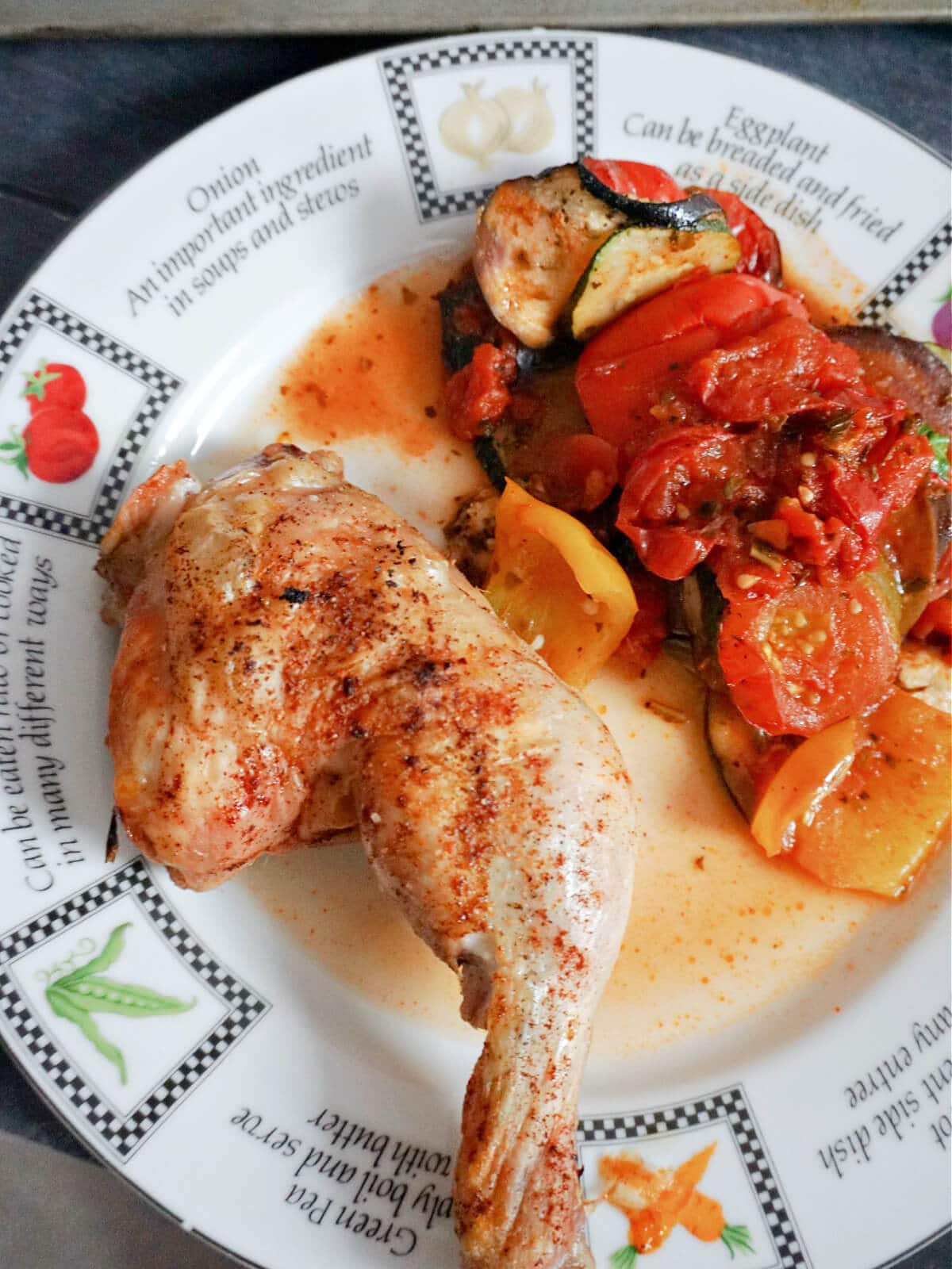 Overhead shot of a plate with a roasted chicken leg and ratatouille