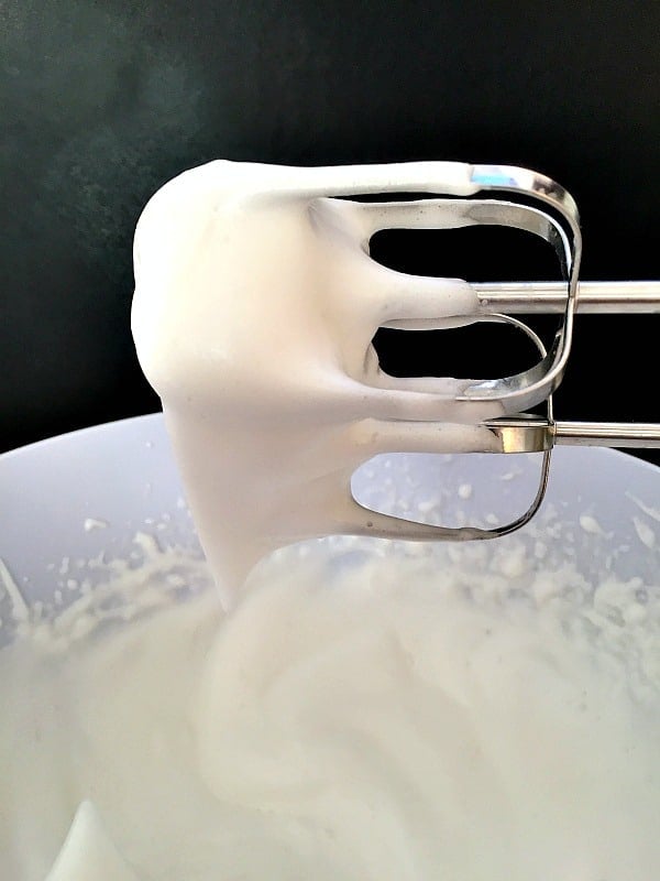 A bowl with aquafaba and a hand mixer