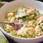 A white bowl with chicken and pea rice