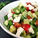 A white bowl with feta and veggie salad