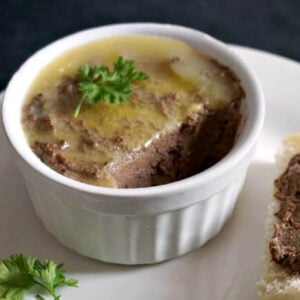 A white ramekin with chicken liver pate