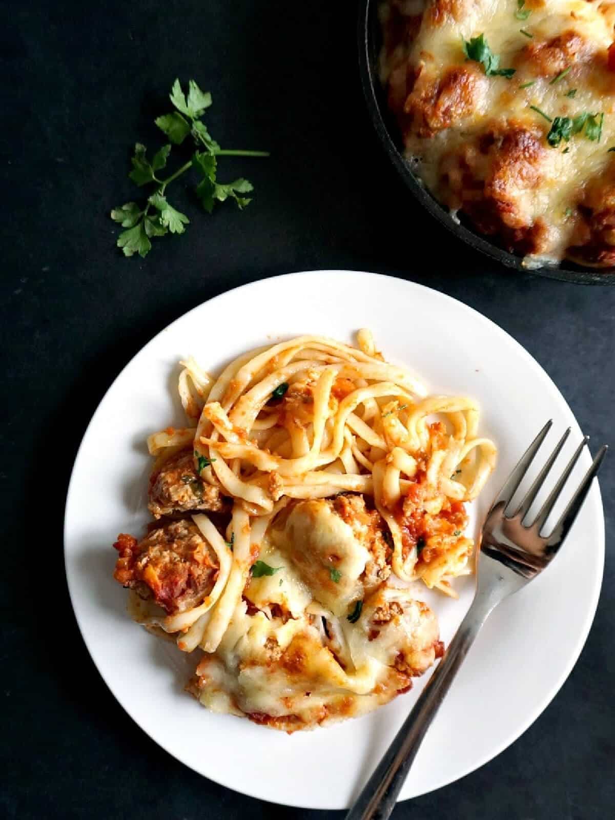 Overhead shoot of a white plate with a portion of spaghetti with meatballs.