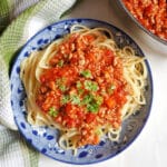 Overhead shoot of a blue plate with spaghetti and bolognese sauce