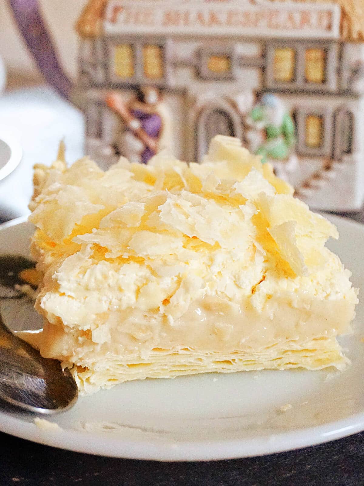 A slice of cremeschnitte on a white plate.