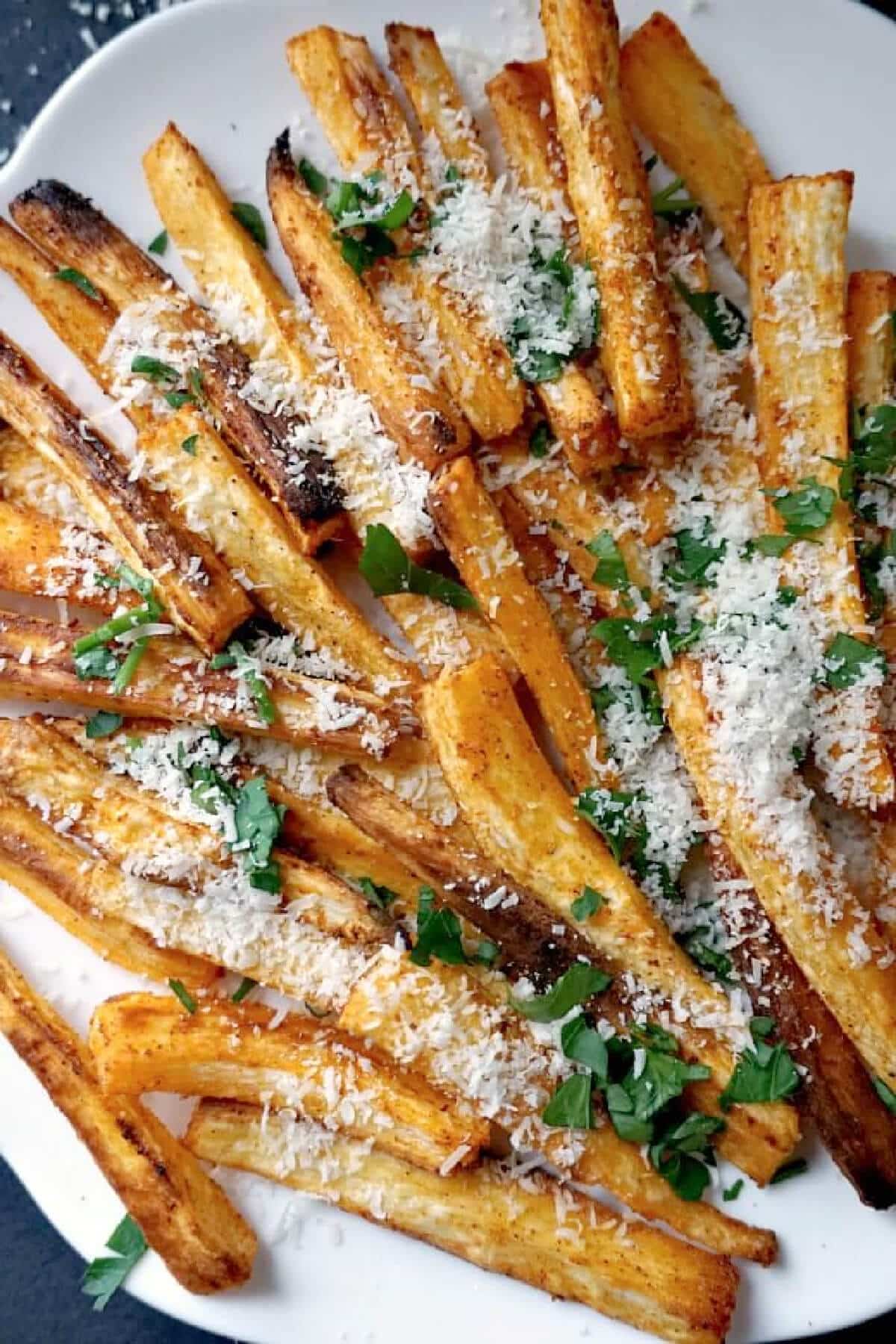 Close-up shoot of parsnip fries with parmesan and herbs.