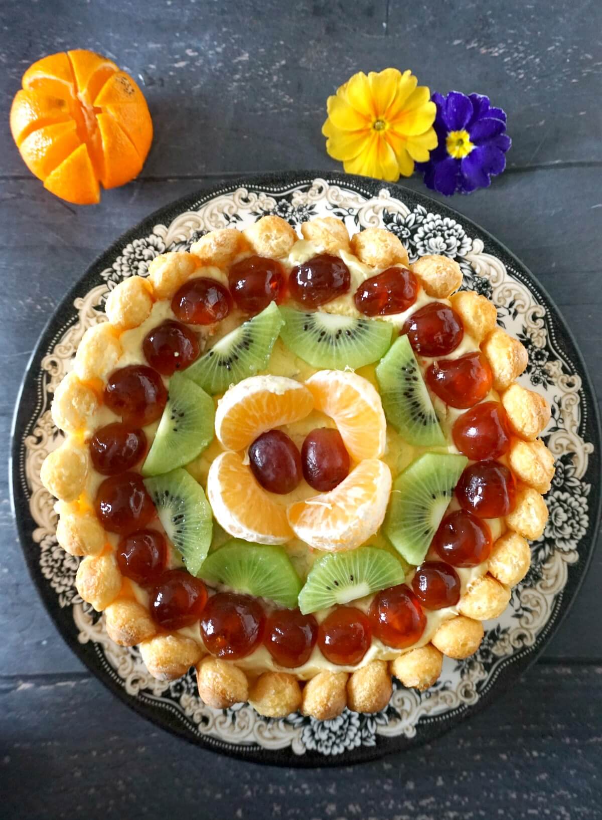 Overhead photoshoot of a Charlotte Cake topped with fresh fruit.