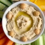 Overhead shot of a white rameskin with spicy hummus