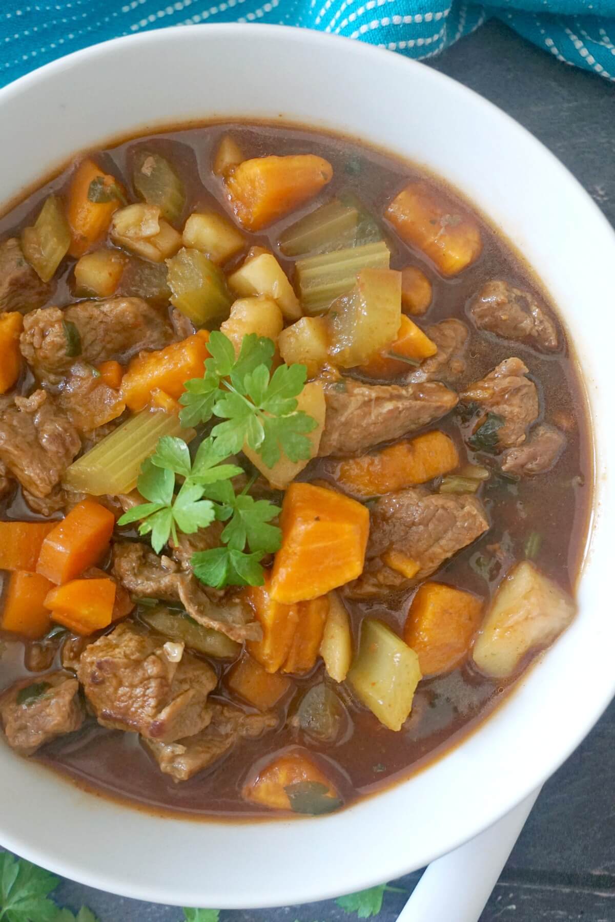 A white bowl with beef and sweet potato stew.