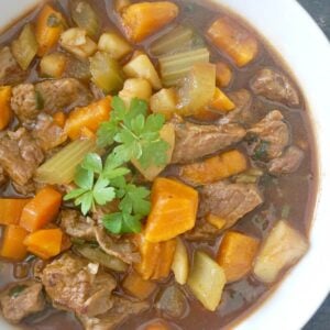 A white bowl with beef and sweet potato stew