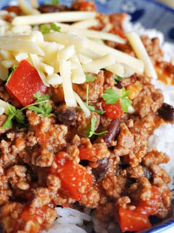 Close-up shoot of a bowl of rice and chili with beans and cheese