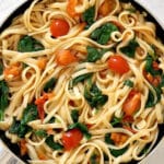 Overhead shoot of a pan with linguini, tomatoes and spinach