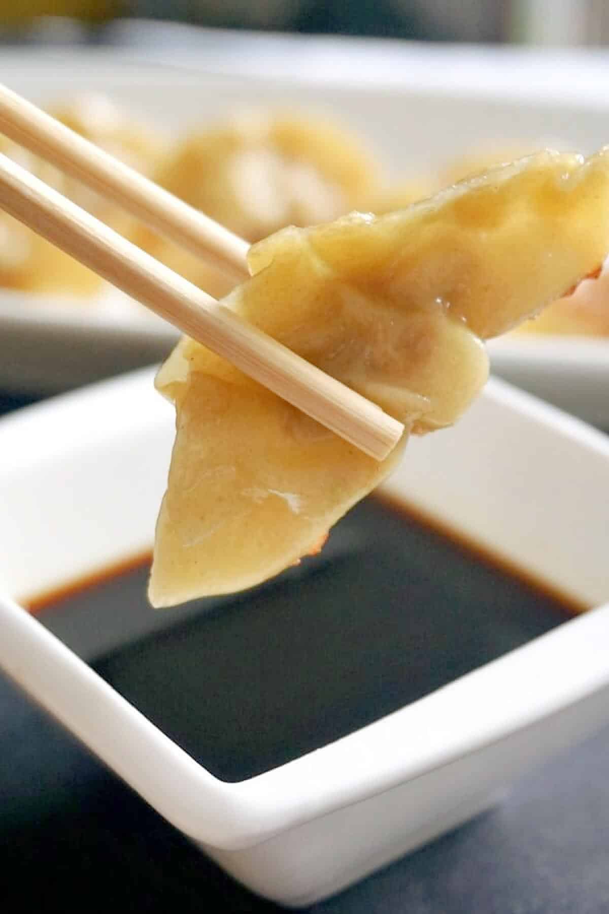 A Chinese dumpling on chopsticks.