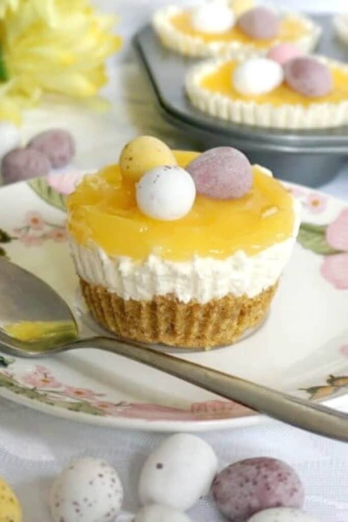 A mini lemon cheesecake topped with lemon curd on a white plate