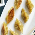 Pan-Fried Dumplings, or Chinese Potstickers made with wonton wrappers and a filling of shrimp/prawn and pork, and a kick of garlic, spring onions and ginger. They are the best dim sums/appetizers for every party, and can be ready in about 15-20 minutes. Why not try them this Chinese New Year? Quick and easy to make, and healthy too, these dumplings are the best of the Chinese cuisine. They can be steamed in any pan with a lid you have. #chinesenewyear, #chinesedumplings, #potstickers, #partyfood