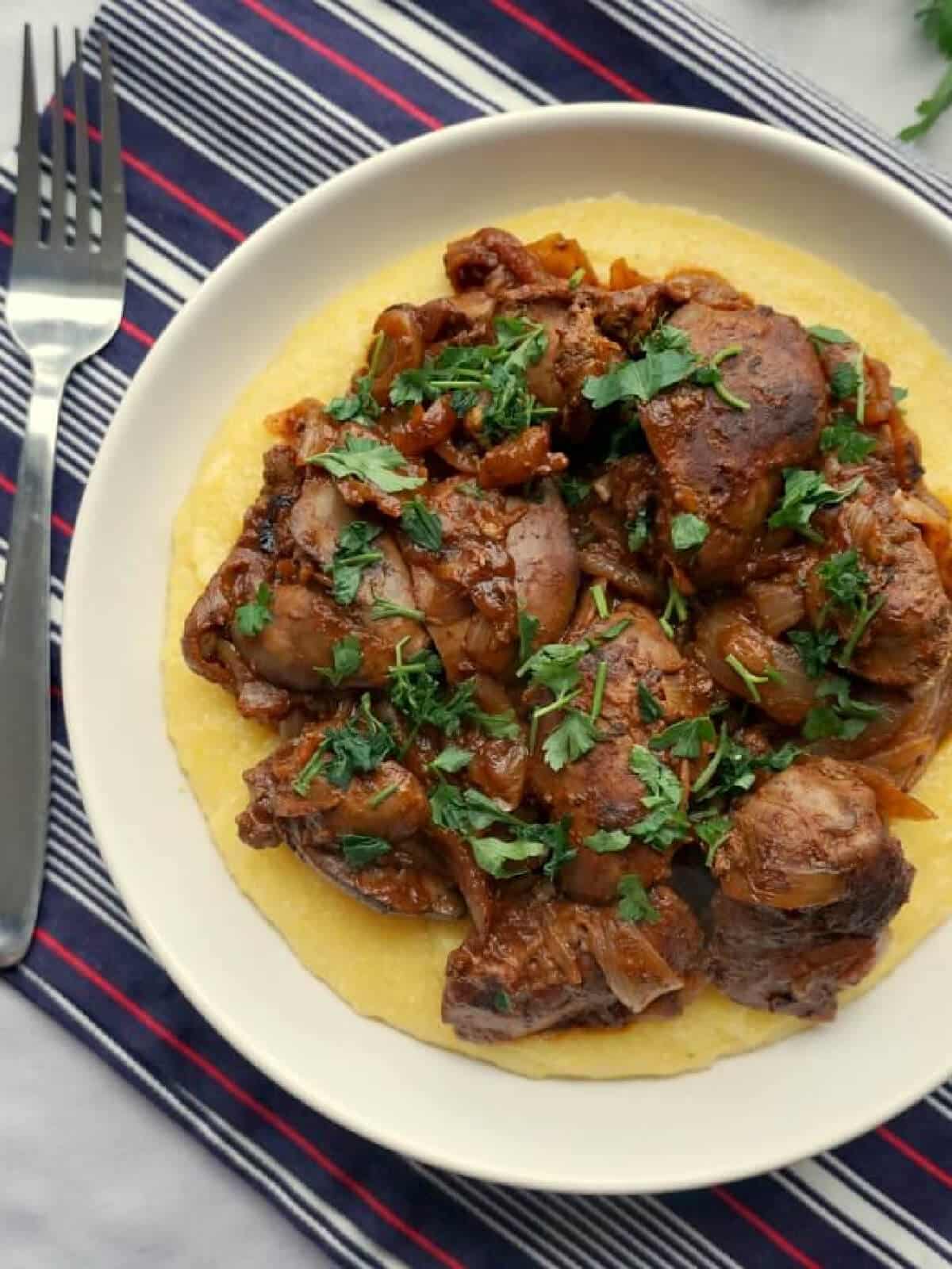 Overhead shoot of a white bowl with polenta and chicken livers.