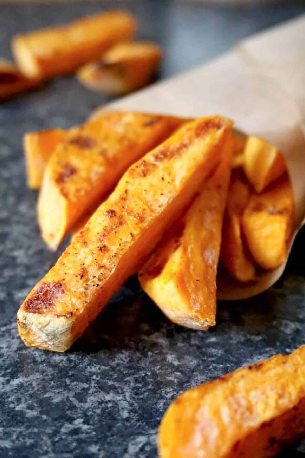A paper cone with sweet potato fries.