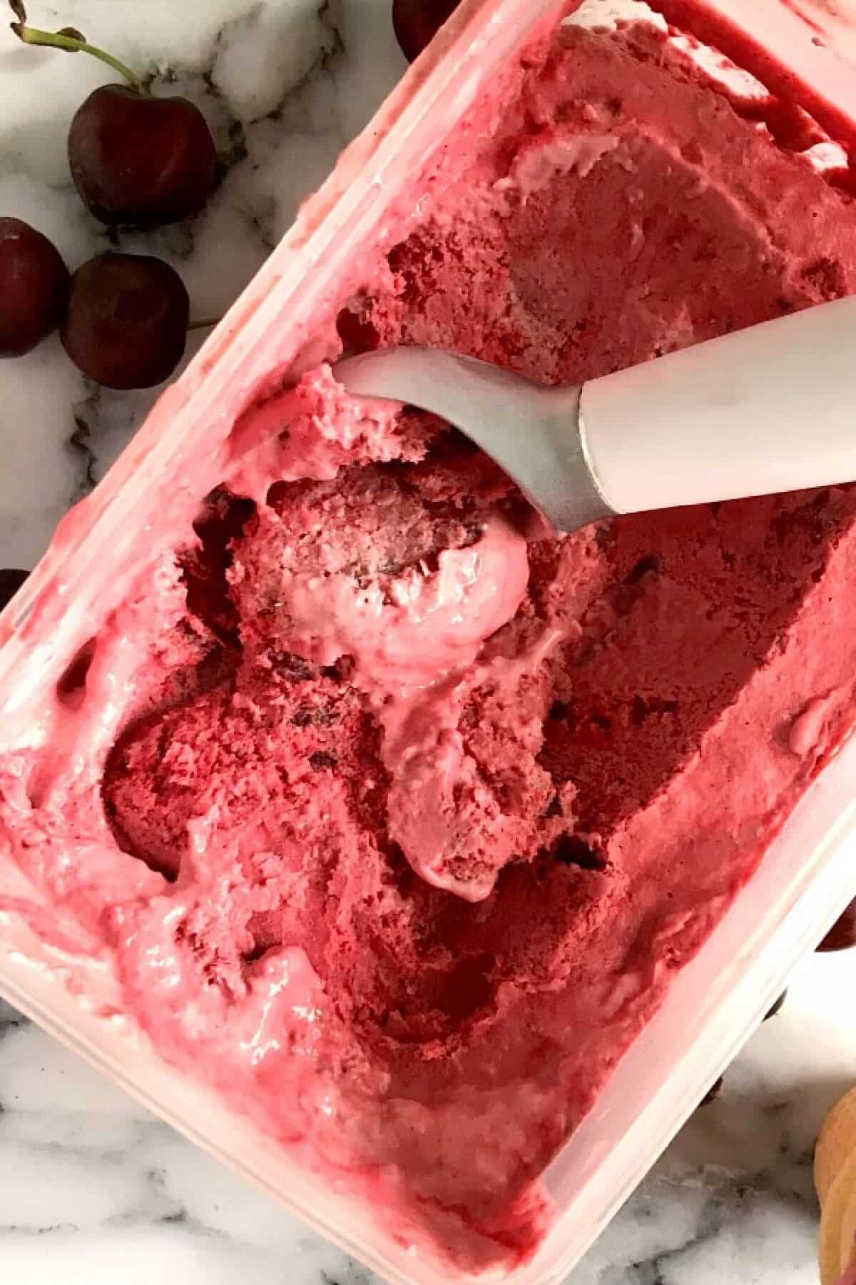 Overhead shoot of a tupperware with cherry ice cream.