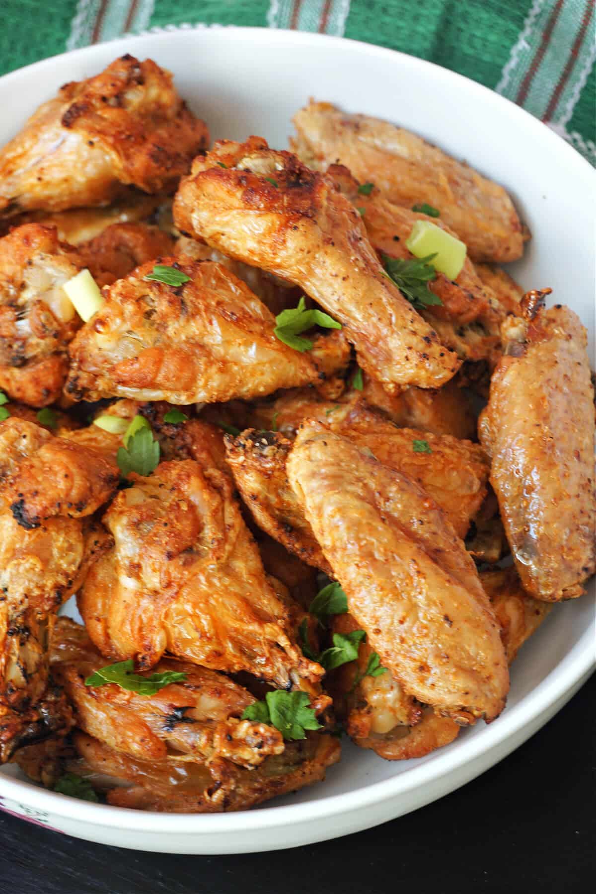 A white bowl with crispy chicken wings.