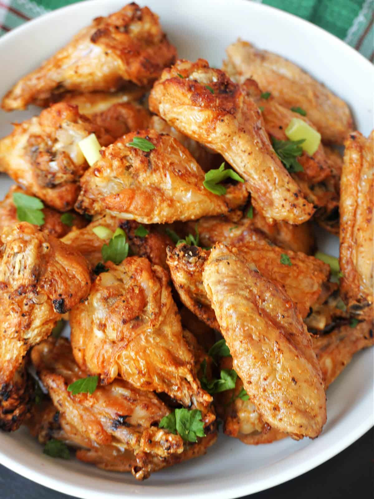 A white bowl with chicken wings.