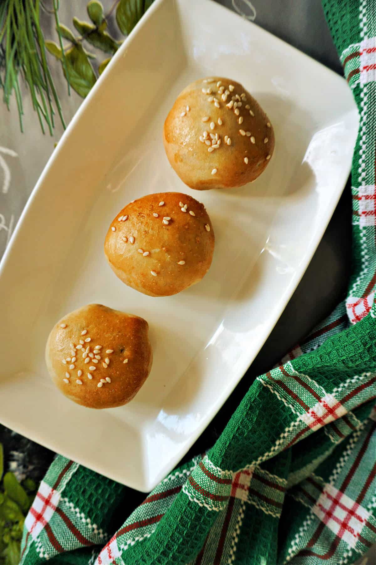 A rectangle serving plate with 3 Chinese buns.