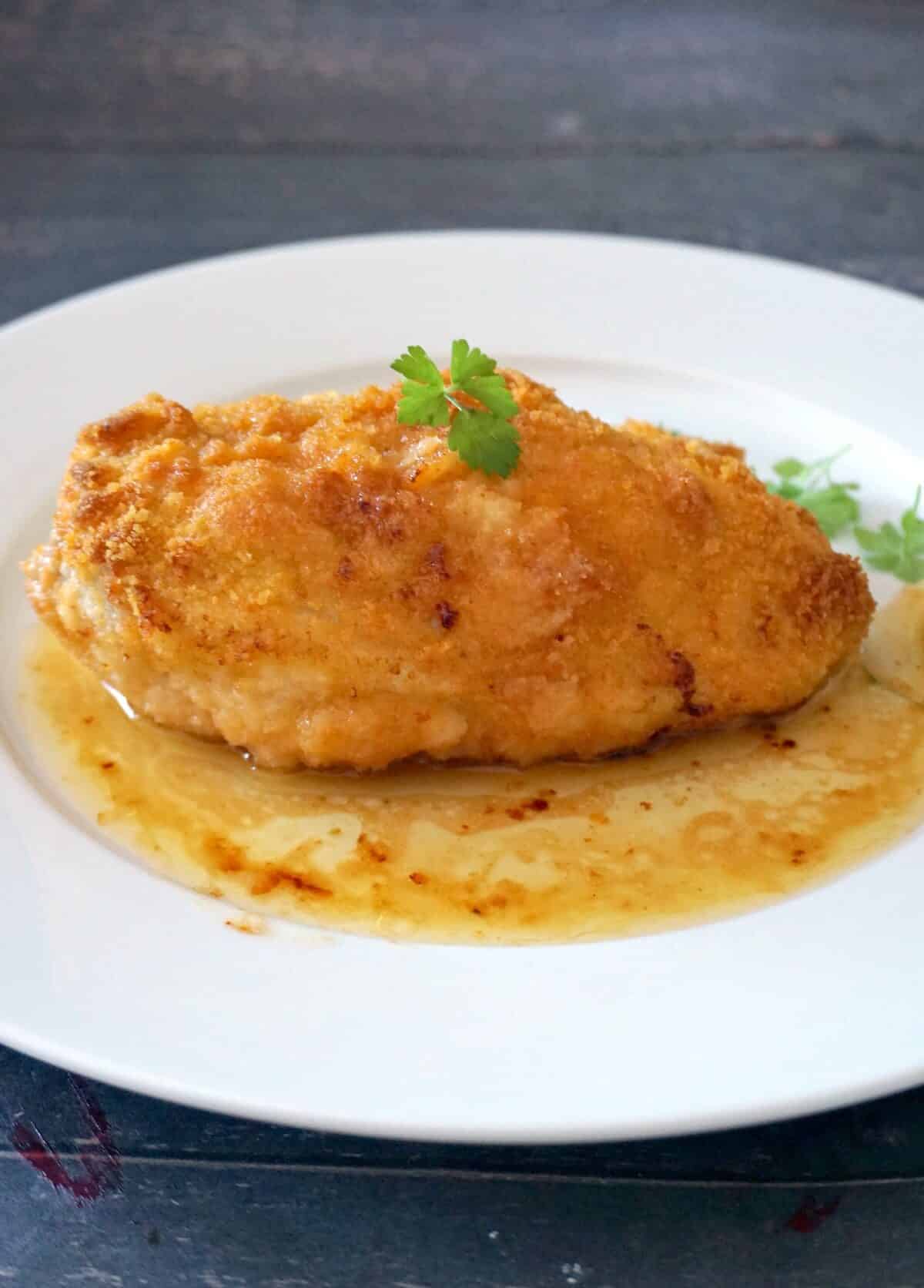 A chicken kiev on a white plate.