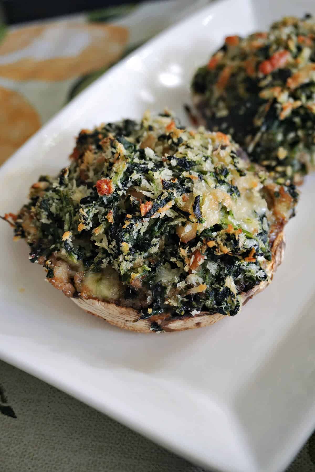A white plate with 2 partially-visible stuffed mushrooms.