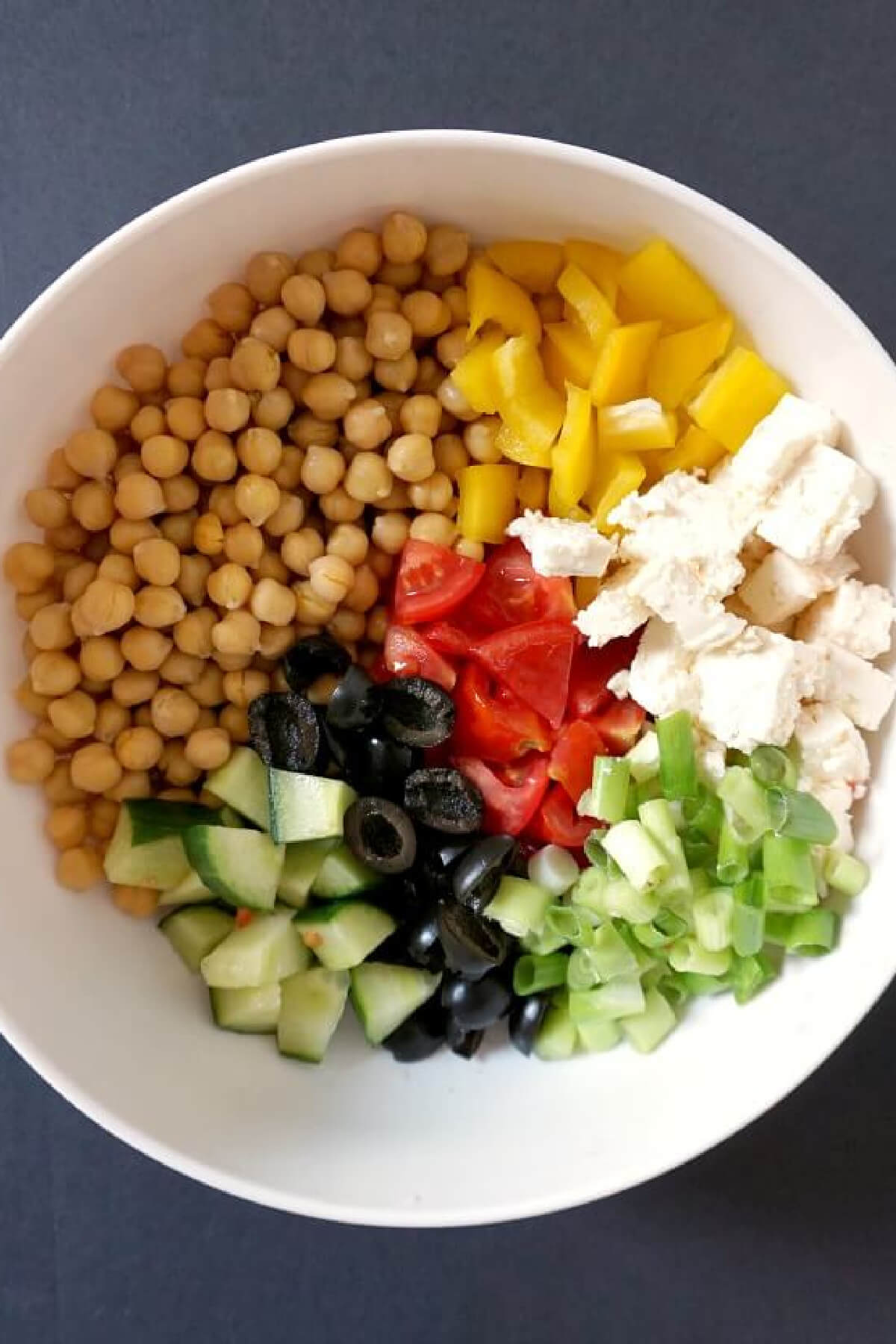 Overhead shoot of a white bowl with ingredients needed to make salad.