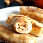 3 Apple Pie French Toast Roll-Ups and half a roll on a white plate