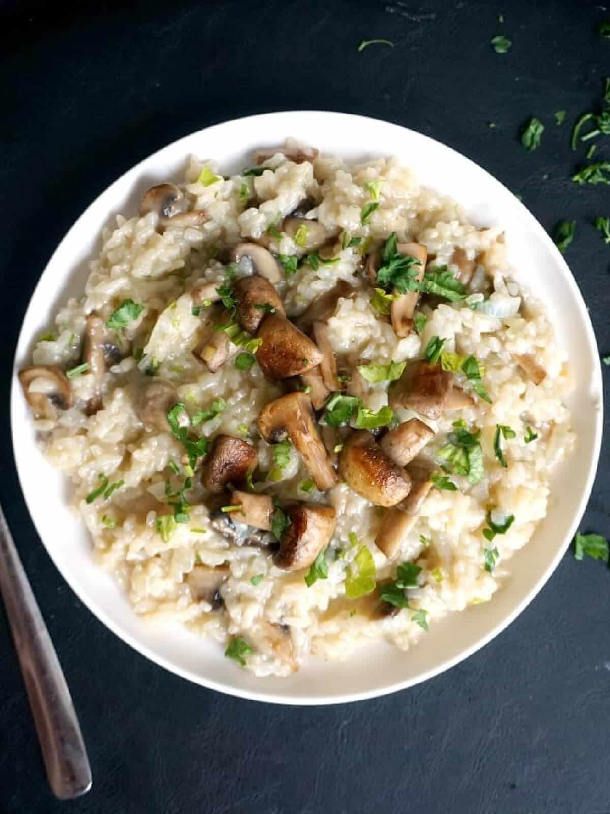 Overhead shoot of a white plate with mushroom risotto.
