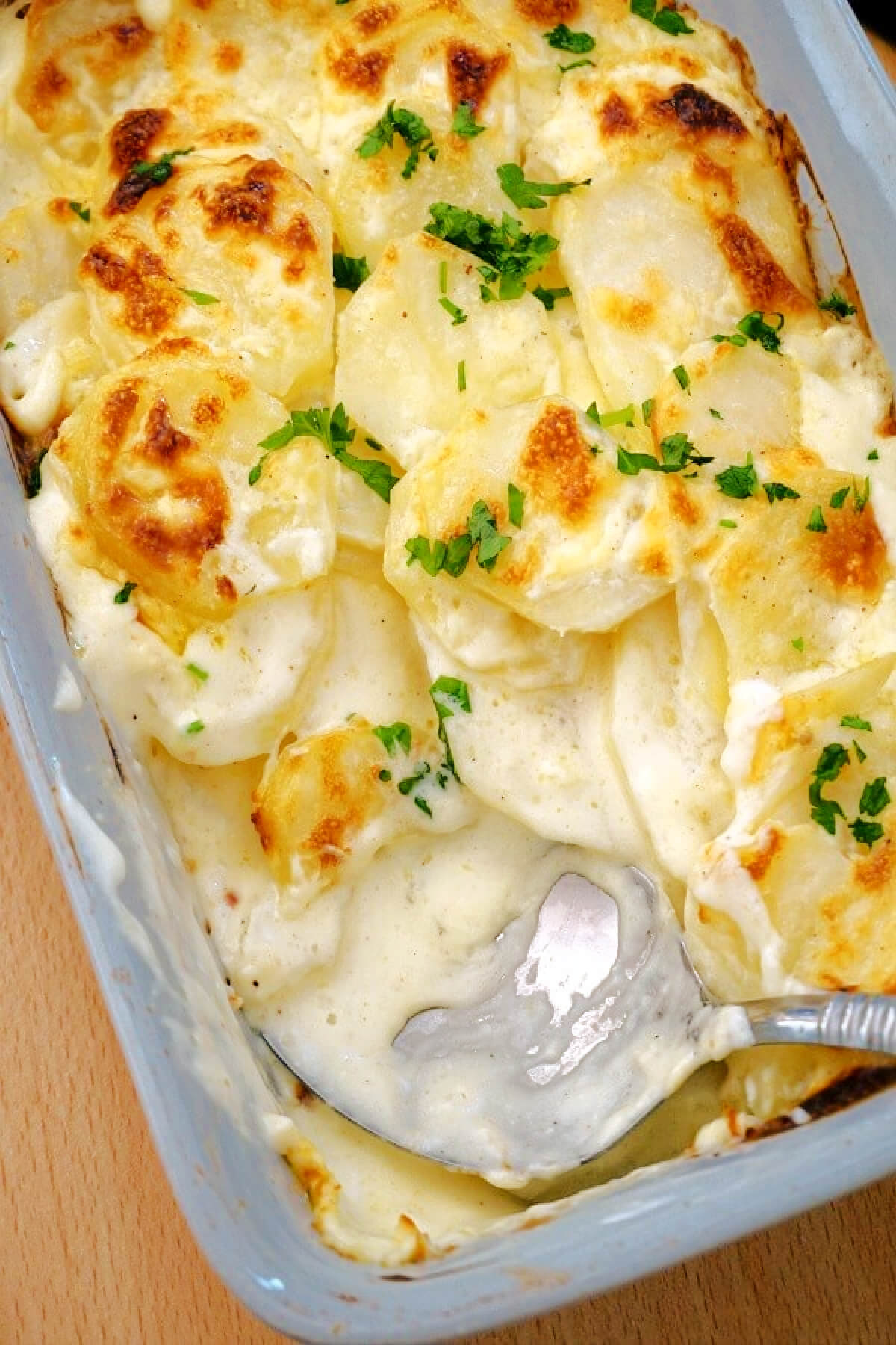 A dish with potato gratin and a spoon.