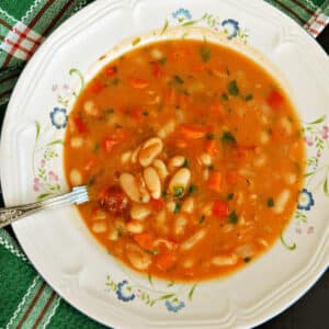 A white plate with bean soup.