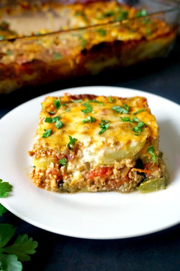 A slice of greek moussaka on a white plate