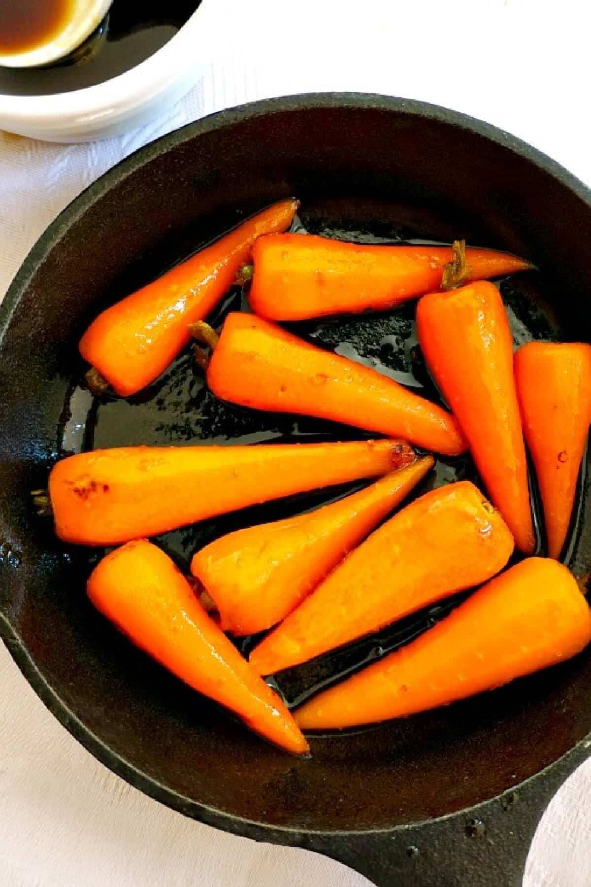 Overhead shoot of a skillet with baby carrots.
