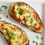 Overhead shoot of a white plate with stuffed aubergine halves