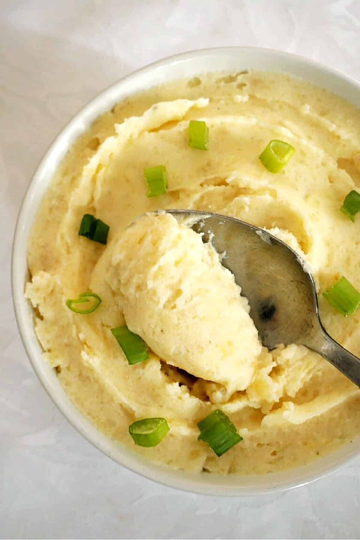 A white bowl with mashed potatoes.