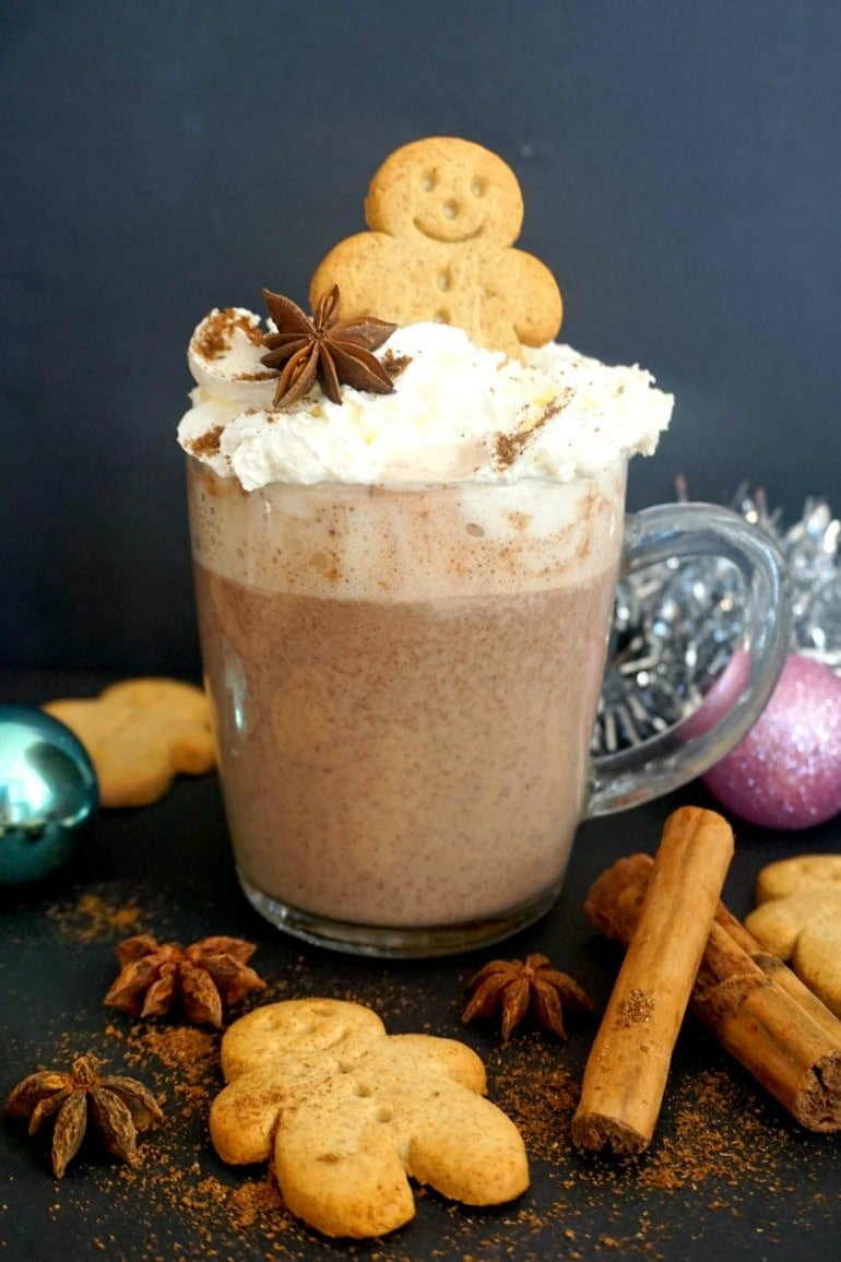 A cup of Gingerbread Hot Chocolate with spices around it