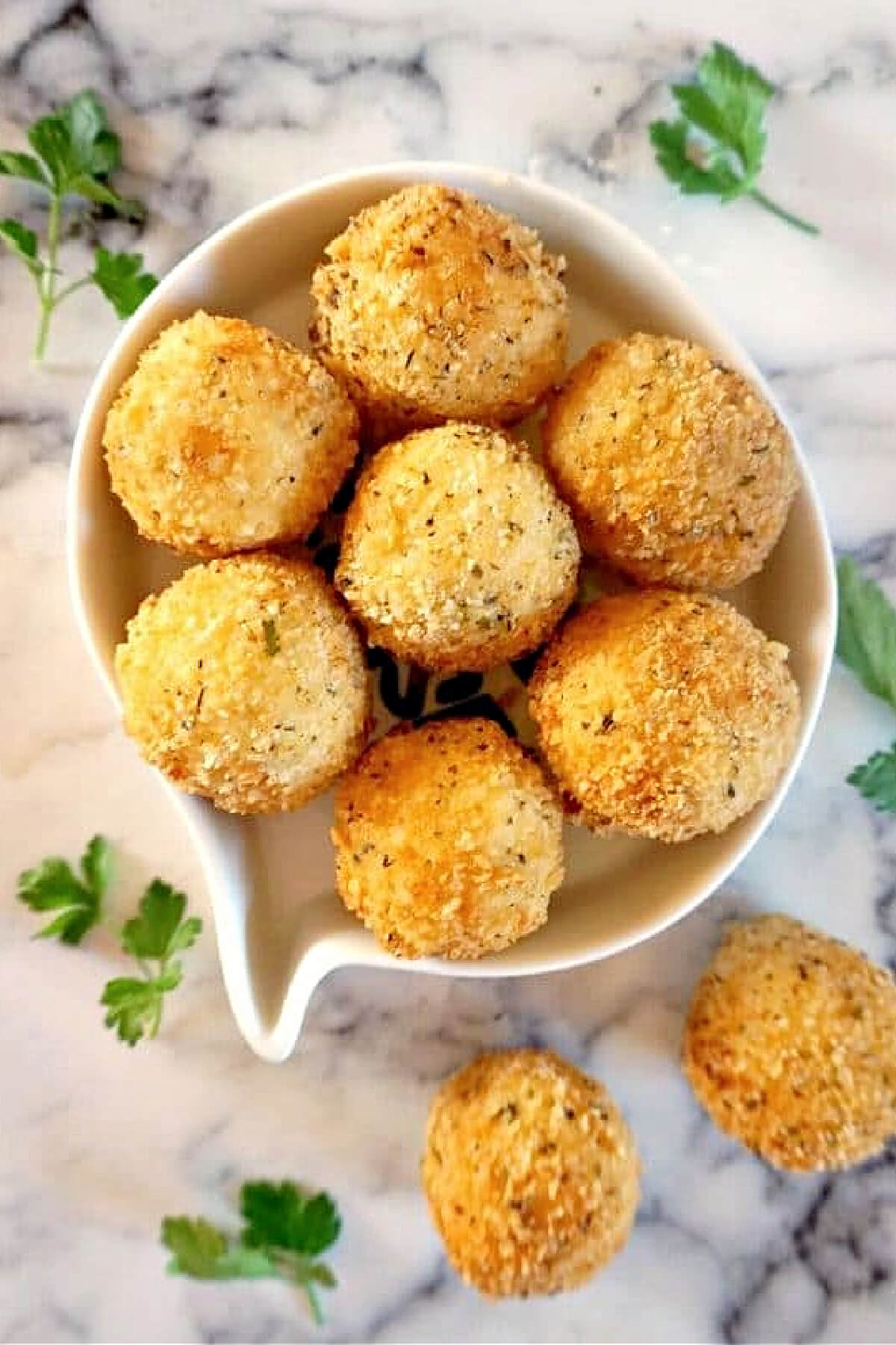 A white bowl with potato balls.