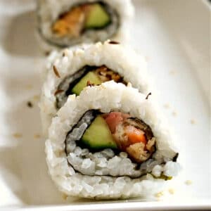 3 sushi rolls on a white plate