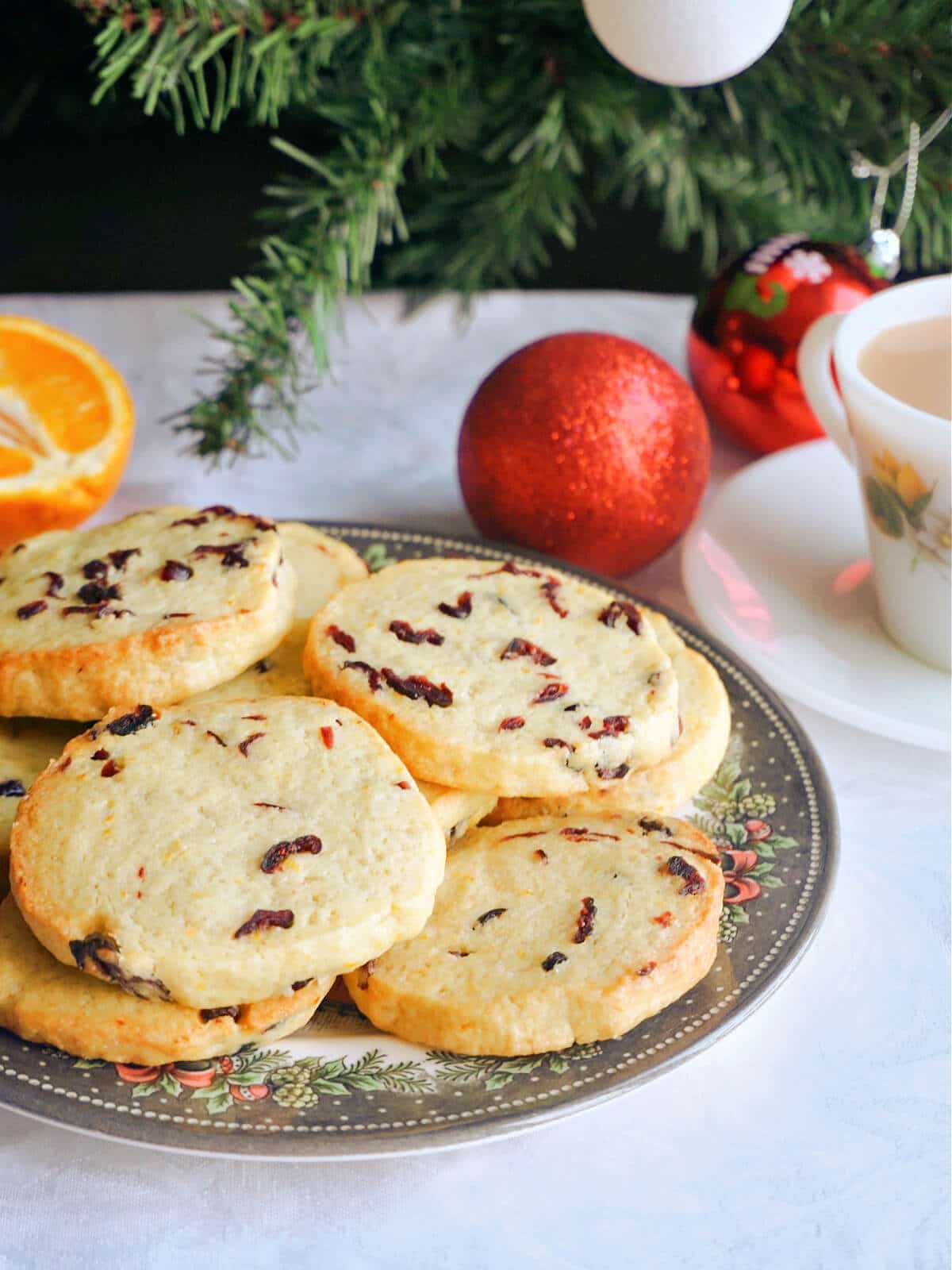 A plate with cookies with Christmas ornaments around.
