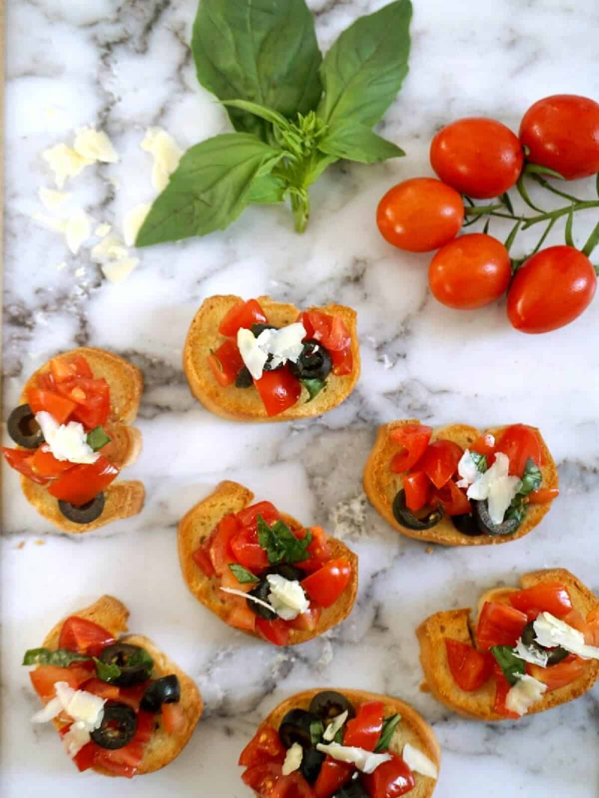 Overhead shoot of 7 tomato bruschettas.