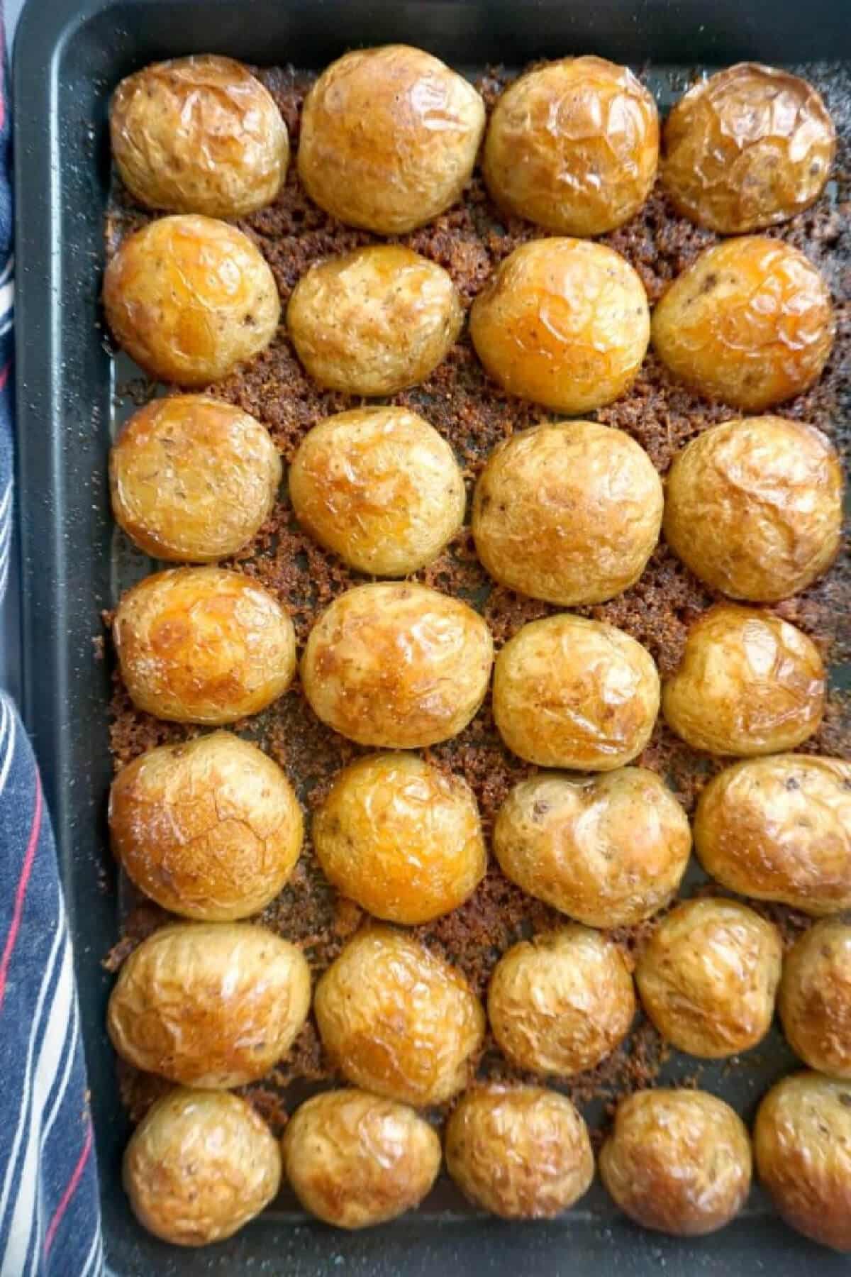 Overhead shoot of a roasting tray with roast potatoes.