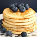 A pile of pancakes topped with blueberries