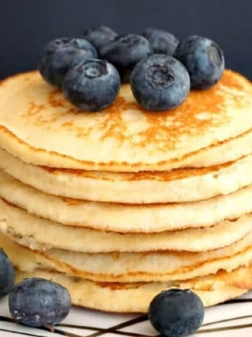 A pile of pancakes topped with blueberries