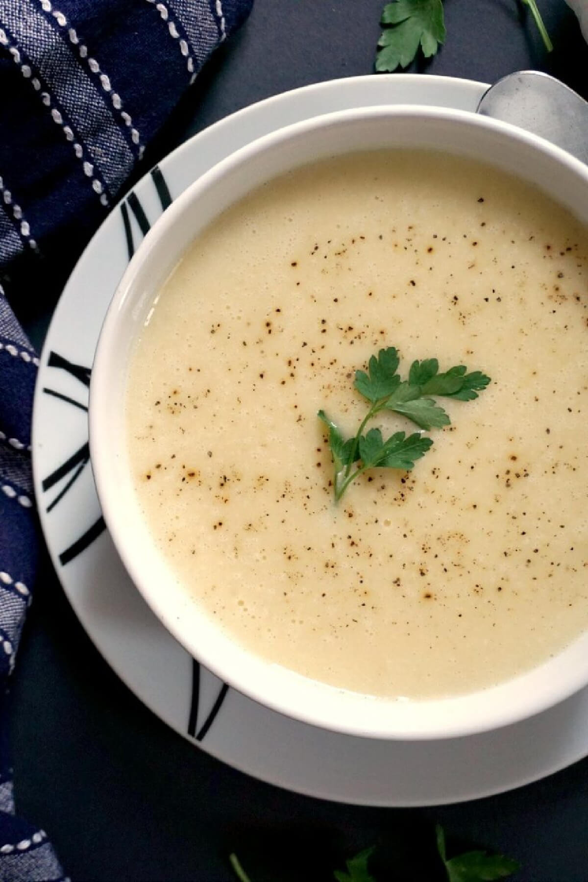 A white bowl of creamy garlic soup.