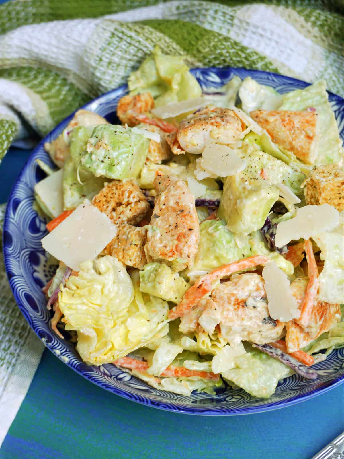 A blue bowl with caesar salad.